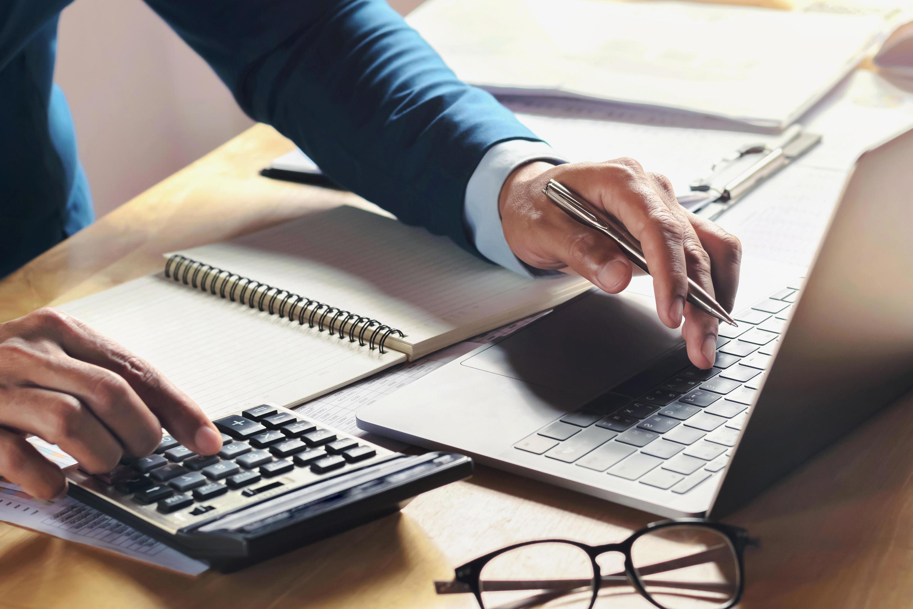 Homme devant ordinateur calculant rendement